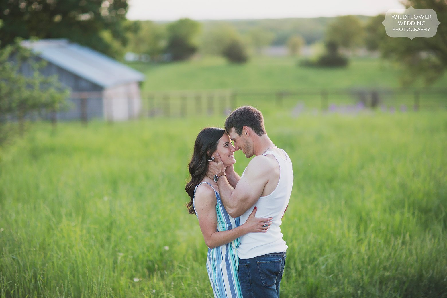 Sexy farm engagement photos with farm boy in wifebeater and girl in striped romper.
