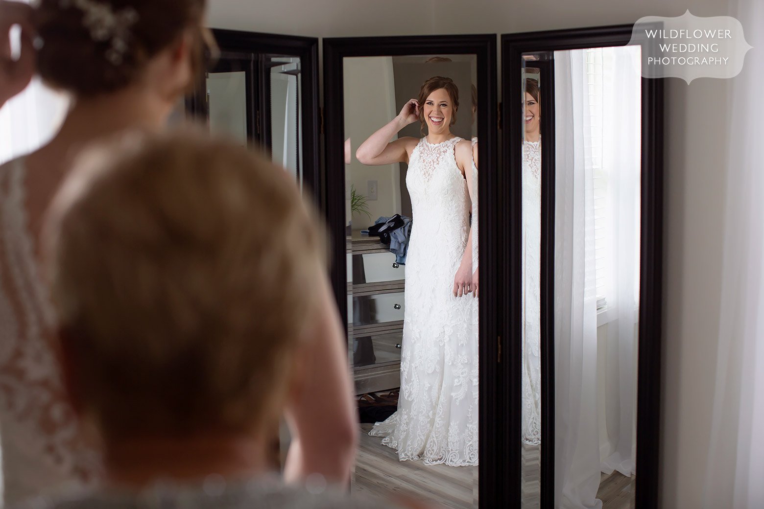 Bride looks at herself in mirror at Cooper's Ridge in Boonville, MO.
