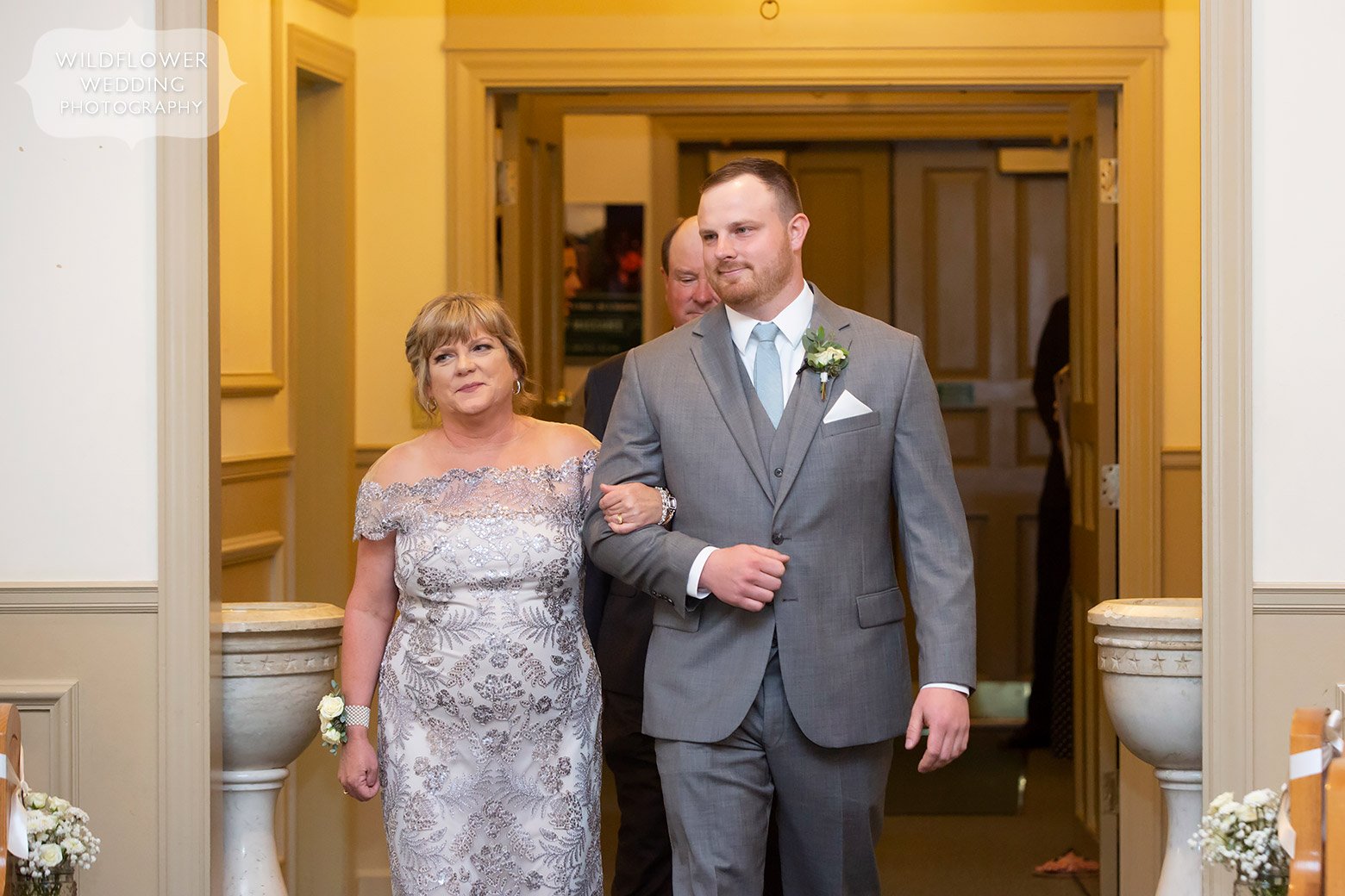 Groom walks down aisle with parents in Boonville, MO.