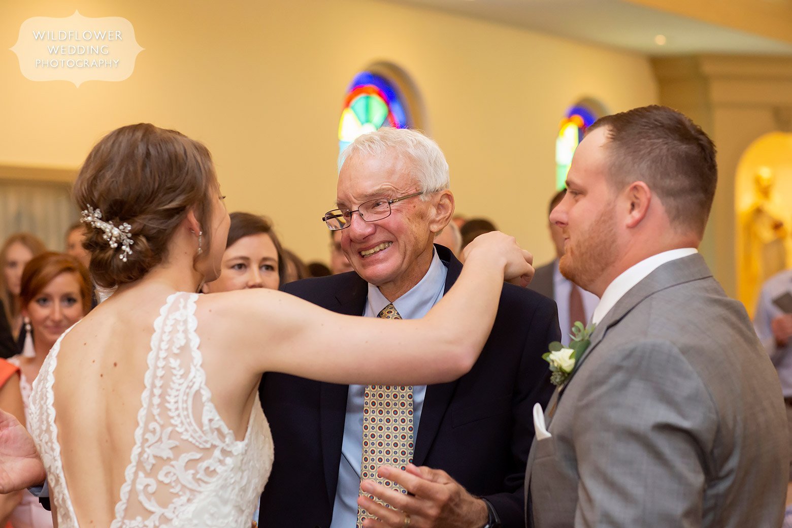 Older man hugs bride after wedding in Boonville.