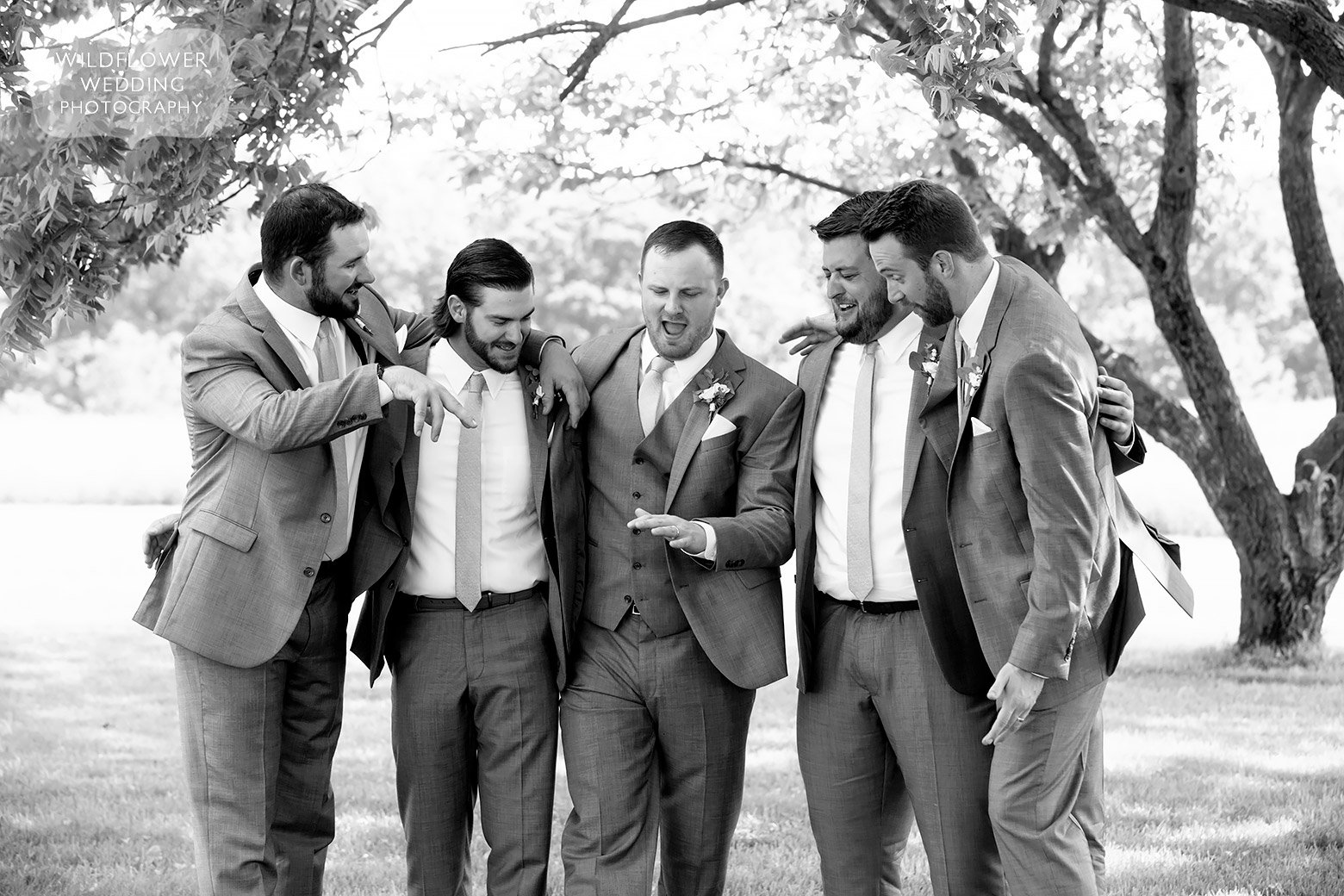 Groom checks out ring with groomsmen in Boonville, MO.