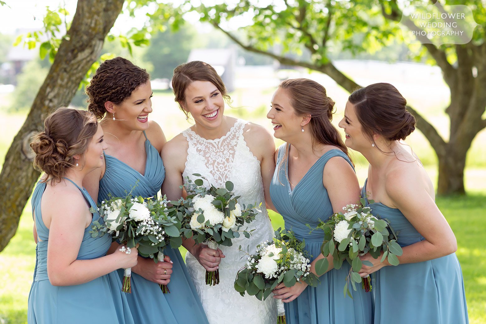 Bridesmaids laughing in the field at Cooper's Ridge venue.