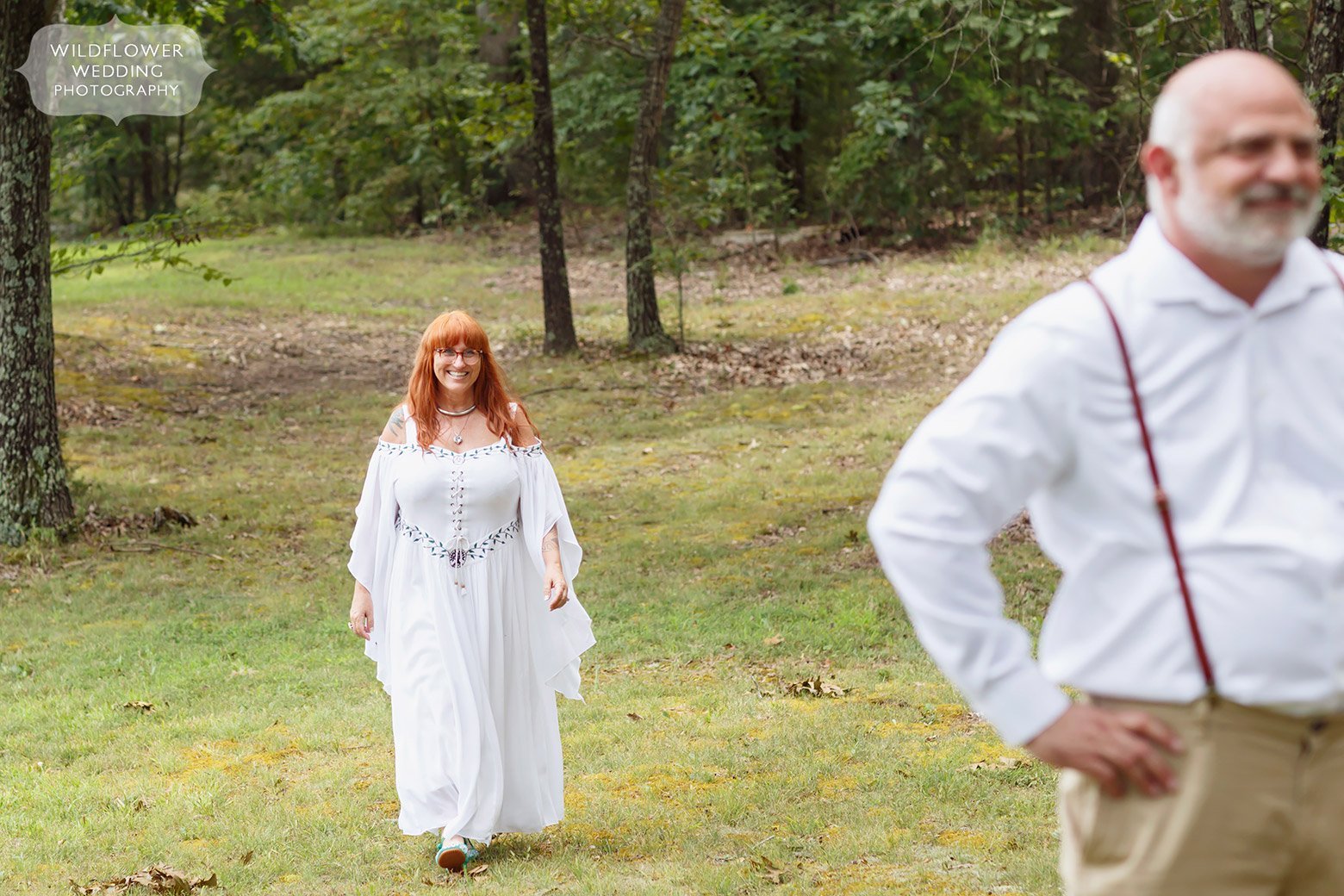 Bride walks into a field for the first look at this Missouri backyard wedding.