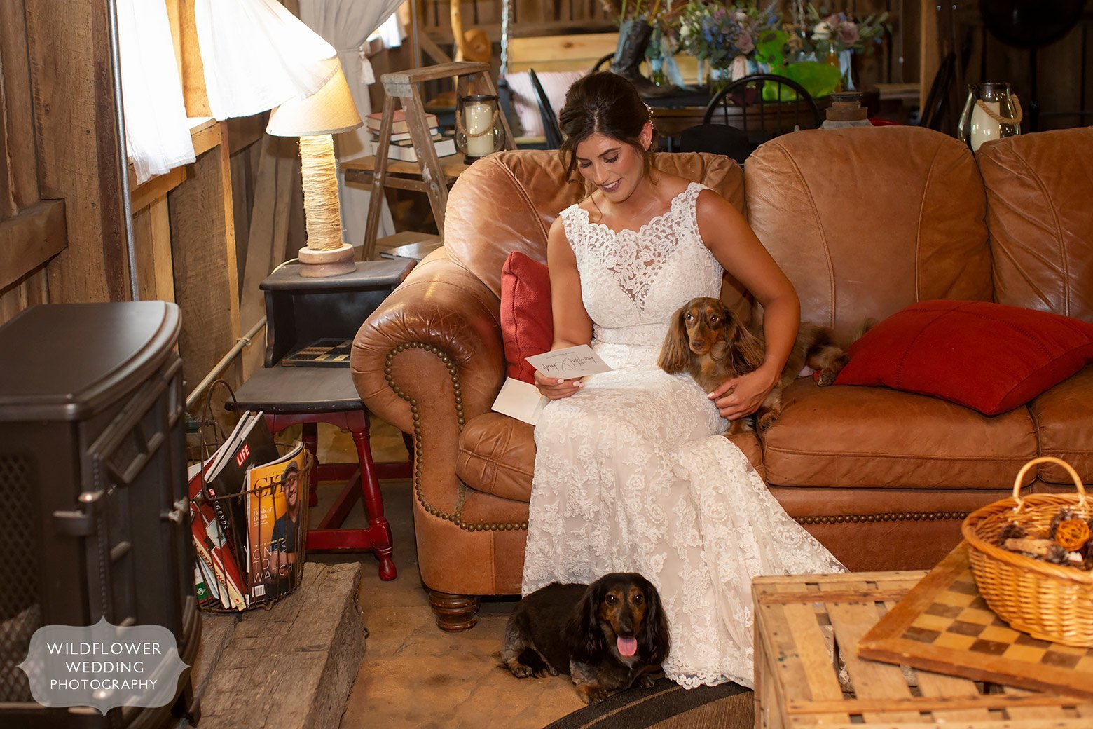 Bride on the couch with dogs while reading groom's letter.