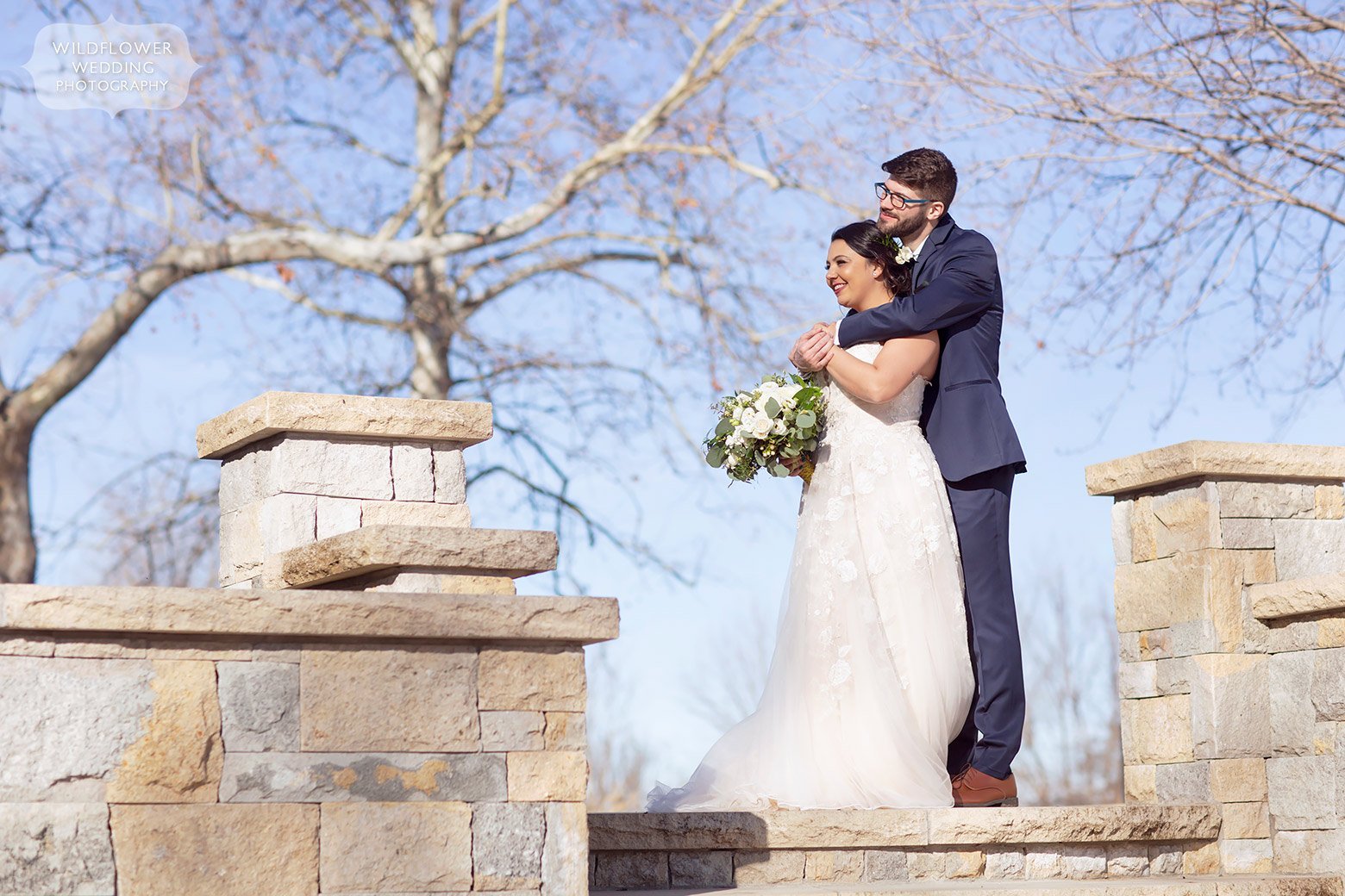 Bride and groom stand on patio at the Brownstone wedding venue in Topeka, KS.