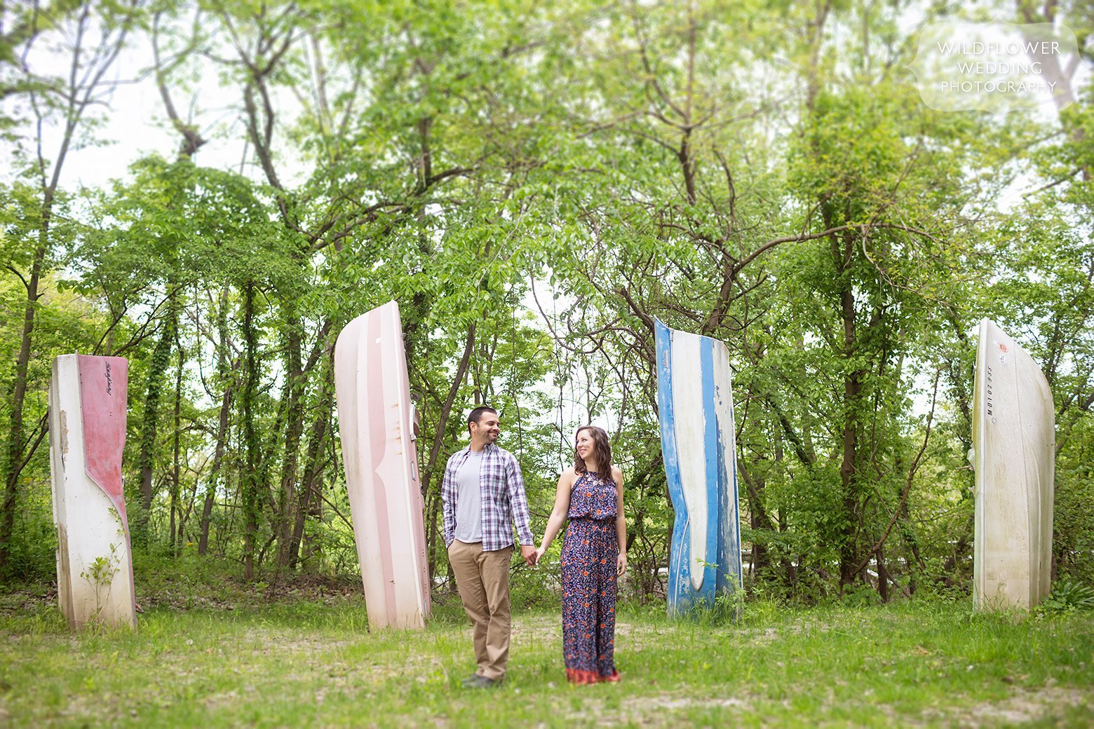 Couple holds hands in front of boat henge at Cooper's Landing.