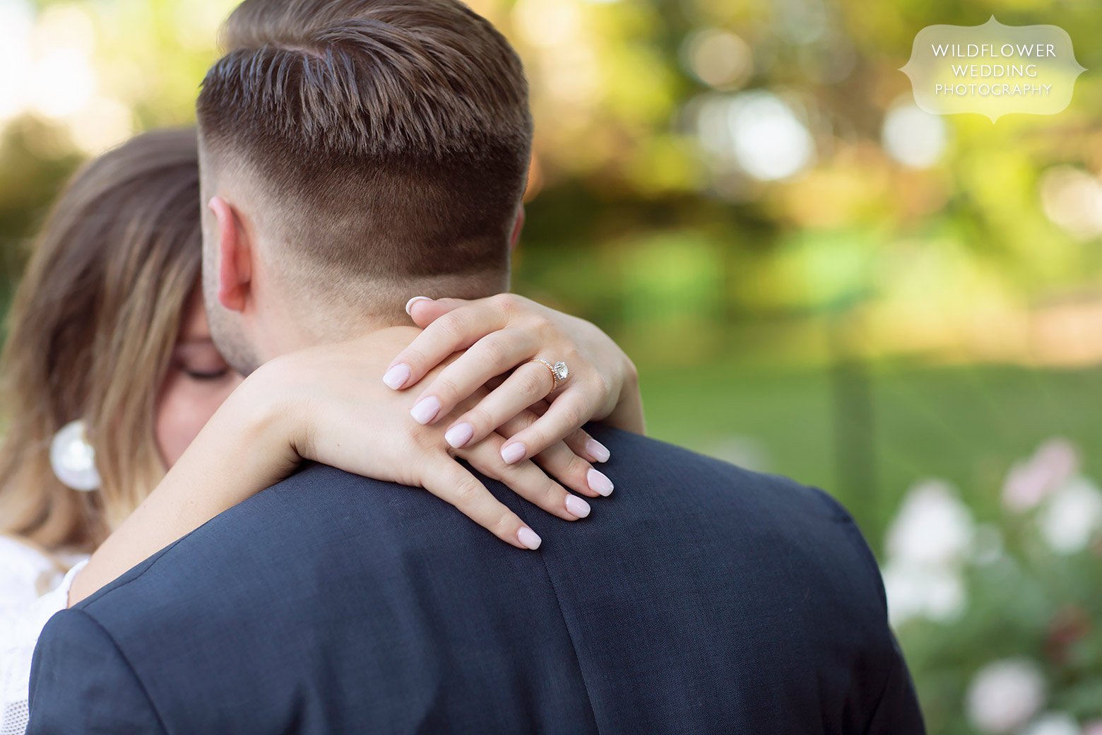 Girl wraps her arms around her fiance during Shelter Garden engagement session.