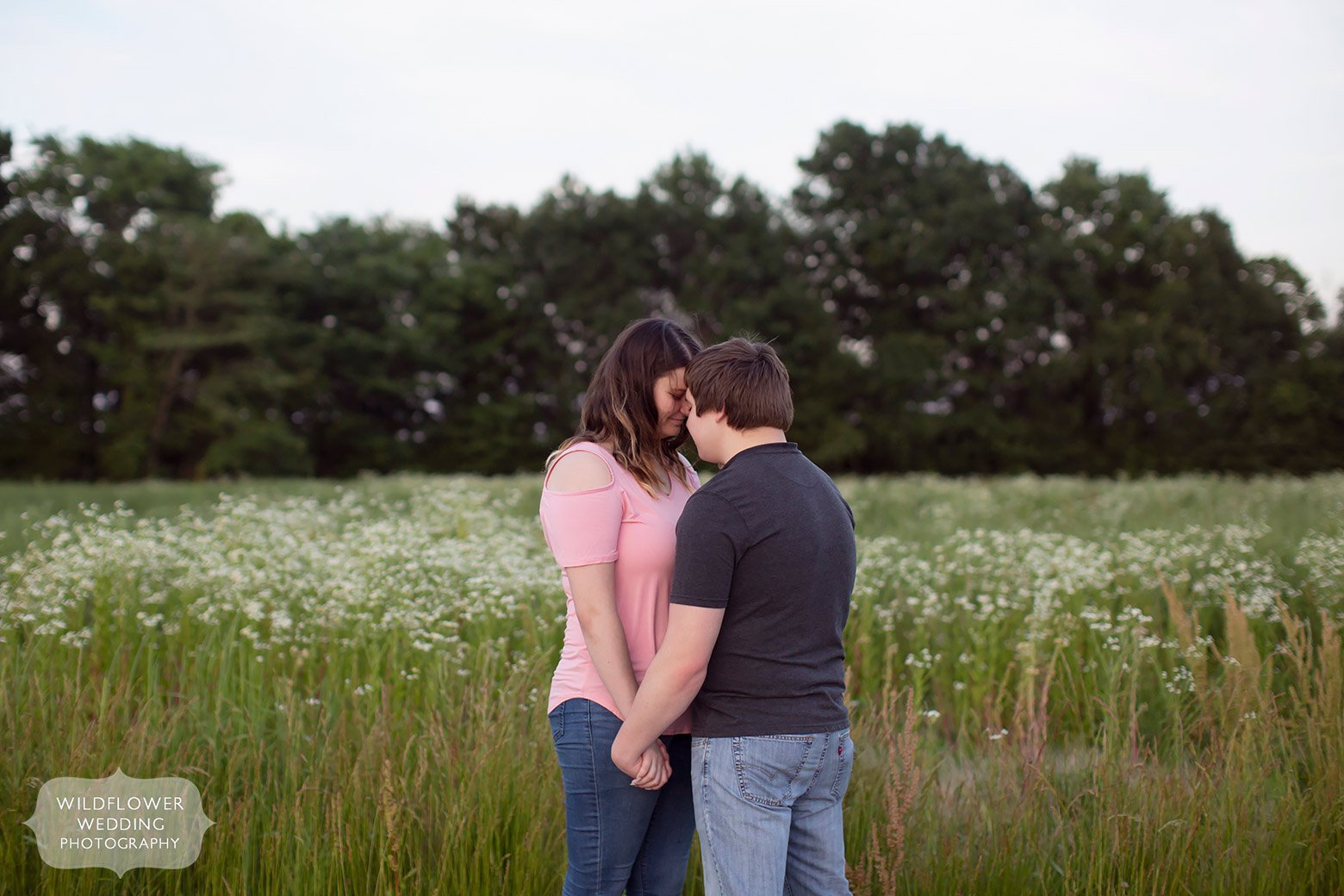 Couple stands in a field of wildflowers at Emerson Fields.
