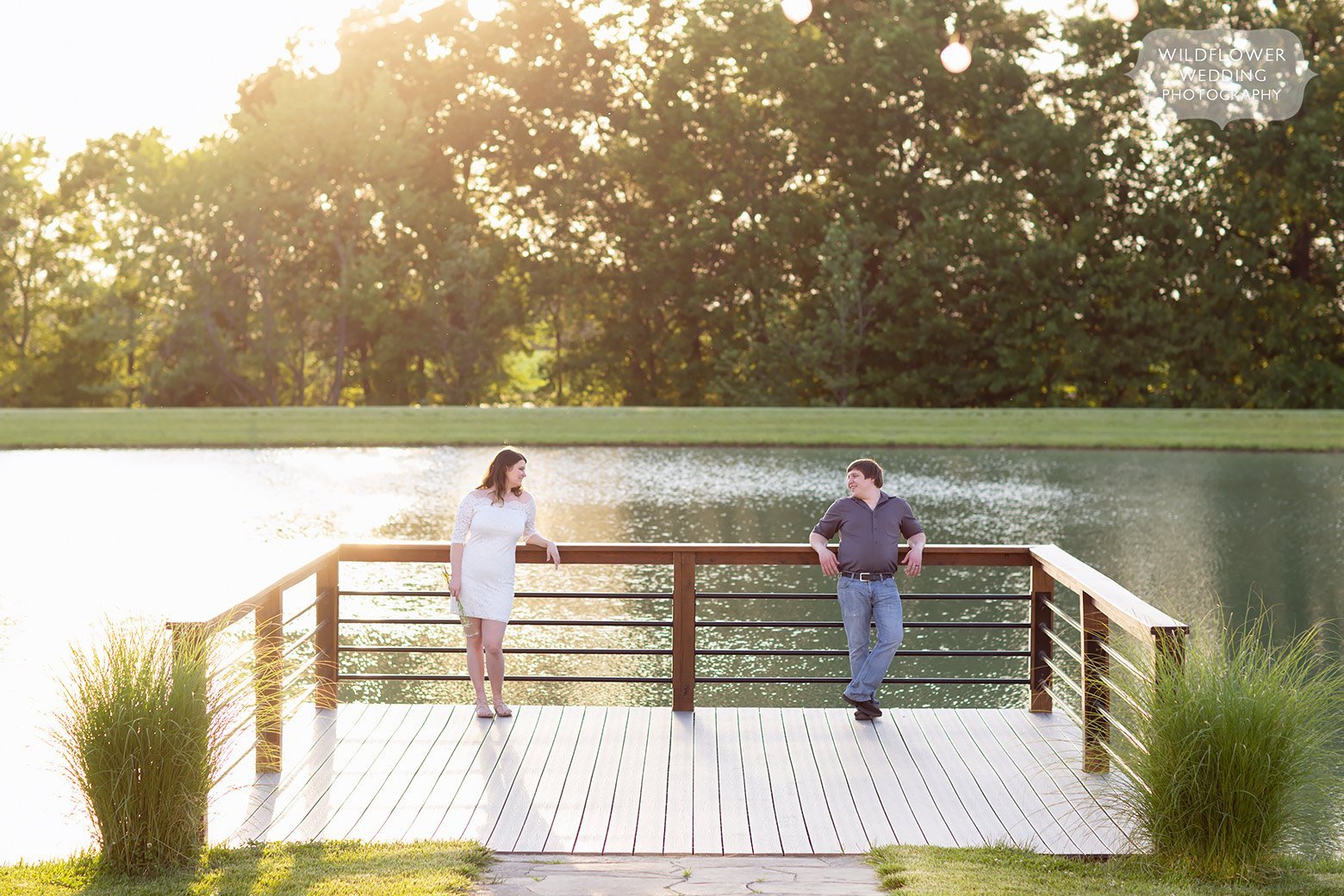 Couple stands on the dock in front of lake at Emerson Fields wedding venue.
