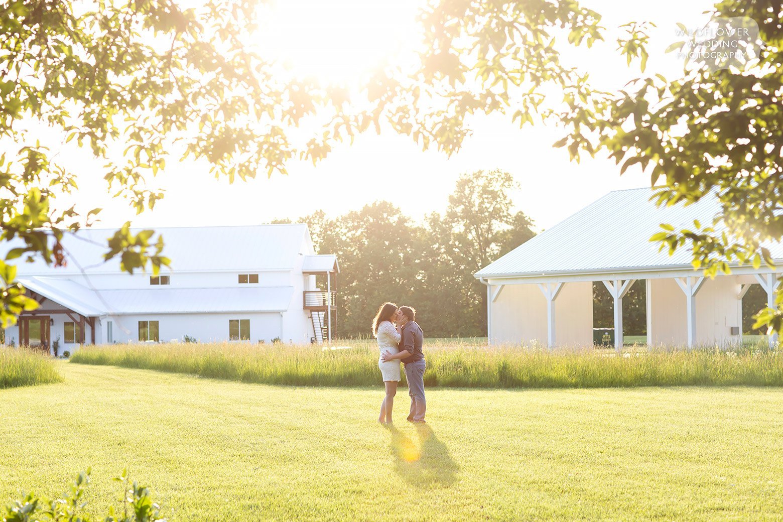 Couple stands in sunshine at Emerson Fields country wedding venue in Missouri.