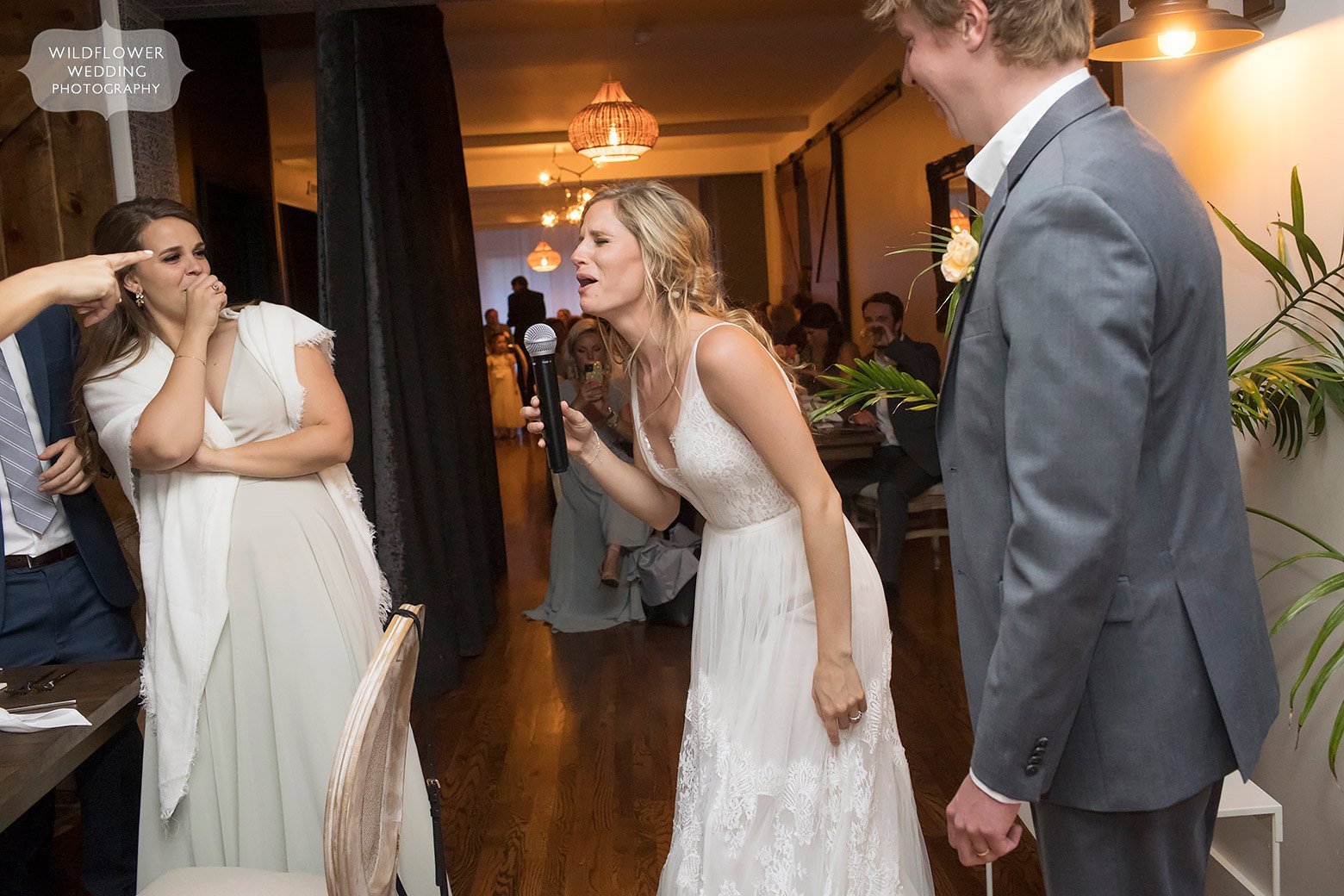 Bride singing with microphone at St. Louis restaurant reception.